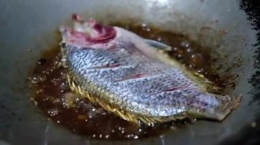 Kızgın yağda kızartılmış tilapia balığına yakın durun. Ev yapımı yemek kavramı.