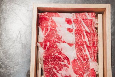 Japon wagyu bifteği, sukiyaki için ahşap kutuda dilimlenmiş.