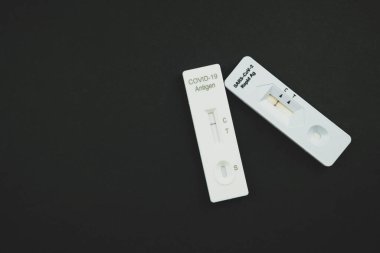 Siyah arka planda COVID-19 ile viral hastalık testleri için bir test kiti.
