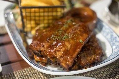 Kızarmış patatesle servis edilen domuz kaburgalarına odaklan.