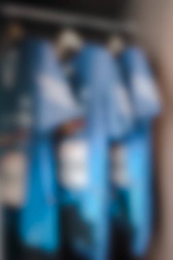 Evdeki erkek kıyafetleri bulanık, soyut bir arka plan.