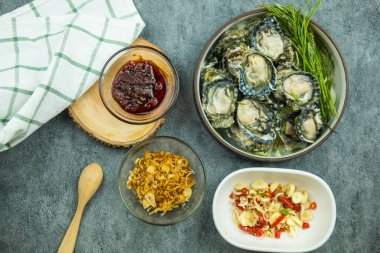 Çiğ istiridye ve meze. Taylandlılar taze istiridye yemeyi sever. Kızarmış sarımsak, acı biber, Tayland biber ezmesi ve daha lezzetli olması için deniz ürünleri sosu da ekleyin..