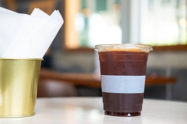 Plastik bardaktaki buzlu kahveyi çıkar (Americano). Kapat.