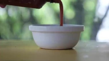 Şişeden beyaz kaseye sukiyaki sosu dök.