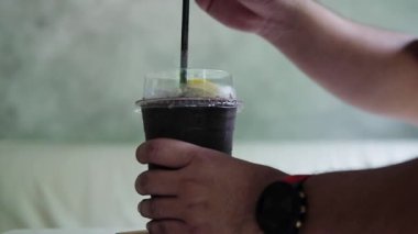 Kafedeki masada duran buzlu kakaoya plastik kamış koymak.