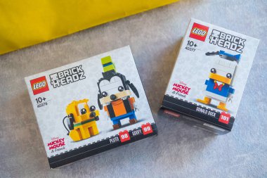 Bangkok, Tayland - 12 Mart 2022: Bir kutu LEGO BrickHeadz ve klasik Disney karakterleri. Koleksiyoncu çocuklar eğlenceli bir LEGO BrickHeadz modeli yapıyor.