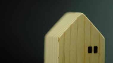 Minyatür ahşap evi siyah arka planda döndür. Gayrimenkul ipoteği ya da satın alma konsepti. İş finans ve kredi