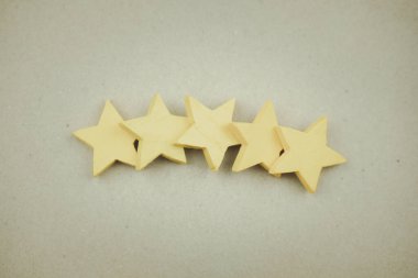 Tahta sarısı beş yıldız, yakın plan. Müşteri tecrübesi, memnuniyet ve en iyi hizmet derecelendirme konsepti