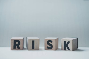 Masanın üzerinde her küpte R, I, S, K harfi olan dört adet küp var. Mali risk değerlendirmesi ve portföy risk yönetimi kavramı