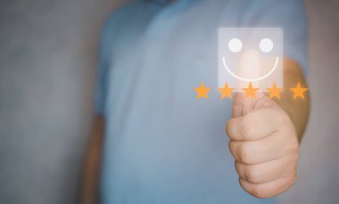 Gülümseyen yüz ikonu ve beş yıldız için baş parmağınızı kaldırın. Müşteri memnuniyeti için en iyi hizmet beş yıldızlı not veriyor. Müşteri geribildirimi, hizmet değerlendirmesi, deneyim, tatmin kavramı