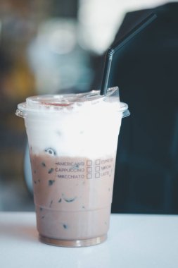 Kahve fincanında buzlu kahve ve kahve dükkanında süt köpüğü.