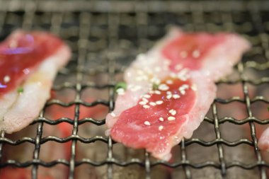 Primi kapat. İnce dilimlenmiş et üzerine susamlı kömür serp. Lezzetli menü