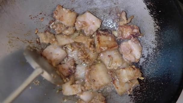 鍋にニンニクとコショウで揚げた豚肉の腹を調理します — ストック動画