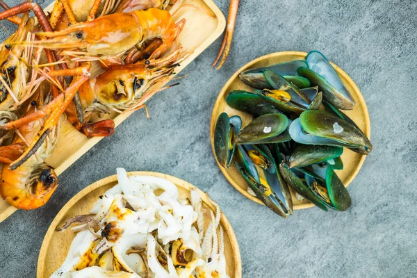 Izgara karides, ızgara kalamar ve ahşap tabakta haşlanmış midye. Tayland 'da ünlü deniz ürünleri