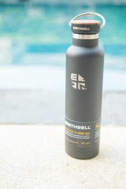 Bangkok, Tayland - 16 Nisan 2022: Ahşap kapaklı ve saplı siyah parlak metal su şişesi, iyi hissettiren el, kavramak için yapılır. Dünya markasının ürünleri.