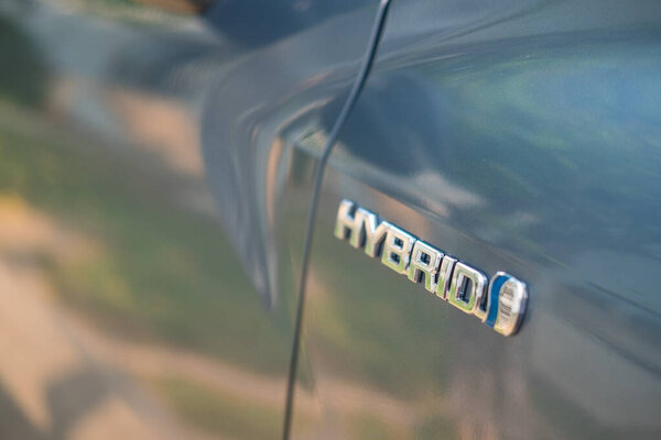 Самут-Пракан, Таиланд - 16 апреля 2022: Закрытие гибридного знака на автомобиле Toyota Corolla Cross с гибридным двигателем объемом 1,8 литра