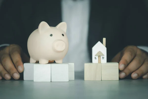 Zakenman Met Het Houten Modelhuis Spaarvarken Als Financieel Spaar Hypotheekleenconcept — Stockfoto