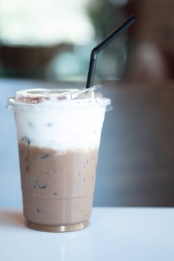 Kahve fincanında buzlu kahve ve kahve dükkanında süt köpüğü.