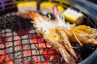 Izgara büyük nehir karidesleri mangal kömüründe kızartılıyor..