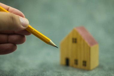 Mühendislik ve mimarlık kalem çizimleri ve mini ev modeli kullanır. Emlak teklifi
