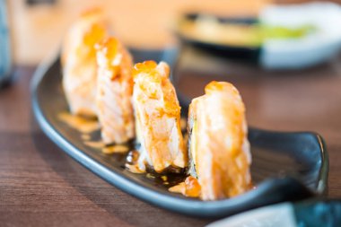 Somon balıklı suşi rulolarının yakın çekimi. Suşili lezzetli geleneksel Japon yemekleri..