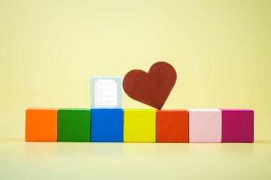 Boş renkli tahta bloğa yerleştirilmiş belge simgesiyle kırmızı kalp şekli