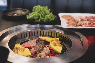 Japon usulü gerçek Yakiniku ızgara. Izgarada ince dilimlenmiş wagyu bifteği ve soya fasulyesi sosuna batırılmış pirinç..