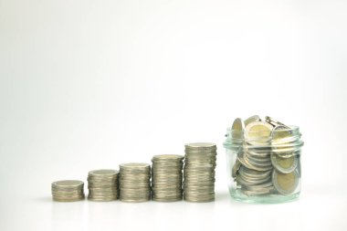 Adım olarak para yığını ve içinde para biriktirmek için bozukluklar, konsept fikri yatırımları, fonlar ve parayı korumak için adımlar olan cam kavanoz..