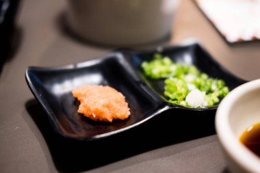 Japon güvecine Shoyu ponzu (Citrus soya sosu) eklemek için kıymalı daikon. Seçici odak