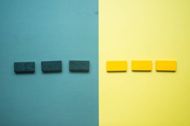 Wooden bar blocks divide divided into two sides black and yellow and on a yellow and black background