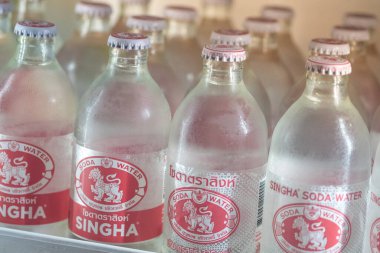 BANGKOK, THAILAND - August 6, 2022 : Bottle of new logo and old logo soda Singha arrange in the grocery store refrigerator. Soda Singha flavored soft drink created by Singha corporation company.,
