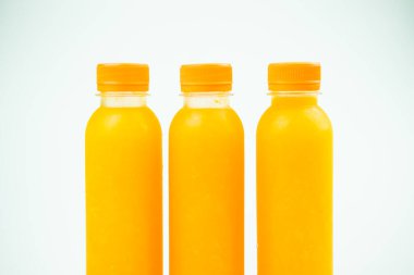 Three small bottles with orange juice. Close up