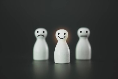 Best excellent business services rating customer experience. Satisfaction survey concept. Chooses a smiley face on a wood doll.