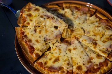 Man takes a slice of pizza melted cheese stretches on slice of hot pizza. Delicious Pizza, close up shot. Nutrition dinner or lunch