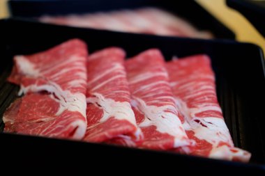Fresh beef raw sliced with marbled texture served for sukiyaki, shabu or yakiniku