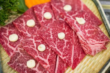 Yakiniku 'ya servis edilen tabaktaki mermer dokuya sahip nadir dilimlerin üst görünümü.