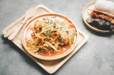 Thai food It called Som Tum, Spicy green papaya salad eating with grilled chicken, grilled liver, grilled chicken ass and sticky rice