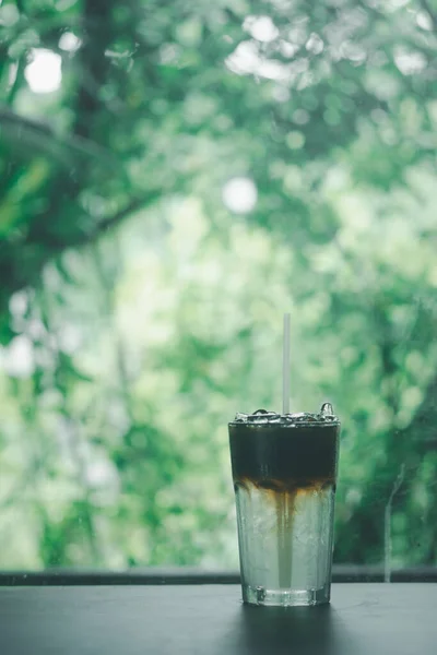Черный Кофе Прохладной Водой Показывающей Два Слоя Помещенный Деревянный Стол — стоковое фото