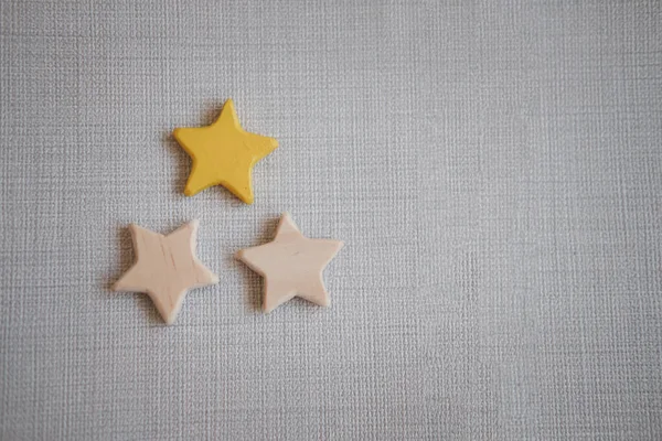 Wooden three star shape and one star painted yellow. The best excellent business services rating customer experience concept.