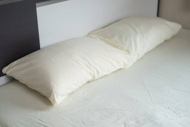 Açık sarı yatak ve yastık rahat evdeki yatak odasında.