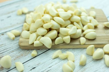 Ahşap kesme tahtasındaki organik sarımsak keskin bir tat, baharat veya baharat olarak kullanılır ve tıpta.