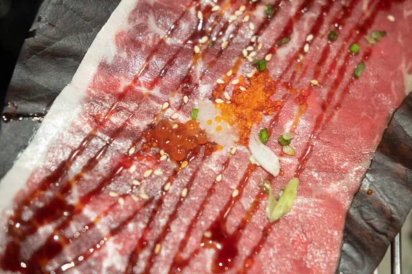 日本料理店で炭火焼のために大庭の葉に置かれる牛肉 — ストック写真