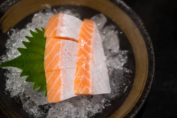 Raw salmon slice or salmon sashimi in Japanese style fresh serve on ice. Close up