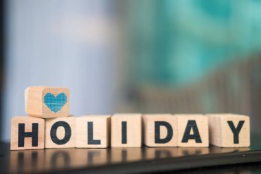 Kampanya ve tanıtım için tahta bloktaki tatil metinlerine mavi kalp ikonu yerleştirildi. Tatile çıkma ve tatil planlama kavramı.