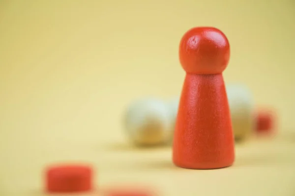 A red wooden figure standing with person figure lie on floor. Concept of successful competition winner and Leader with influence and winner among the losers. Business strategy