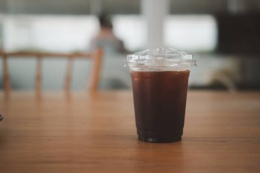 Cate 'deki ahşap masada soğuk kahve bardağı.