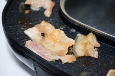 Elektrikli ızgarada et, evde arkadaşlarla barbekü yemeği.