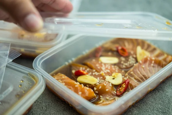 男人的手打开一盒鲜鲑鱼的盖子 韩式酱油腌制韩式食品 — 图库照片