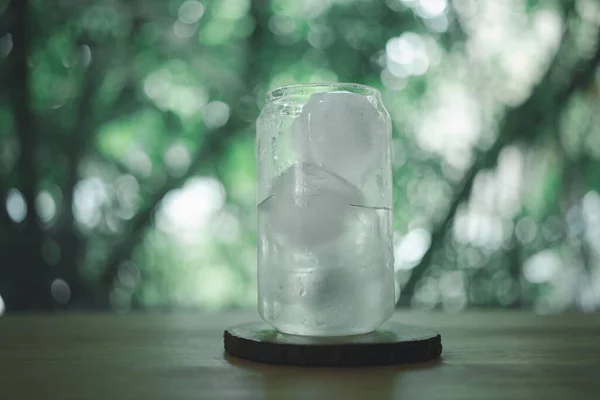 Beautiful glass of water with ice ball on wood table