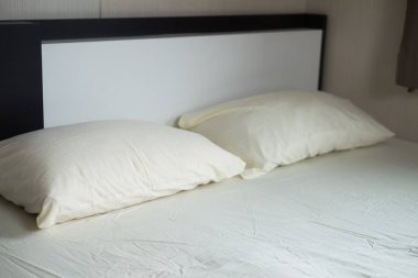Açık sarı yatak ve yastık rahat evdeki yatak odasında.